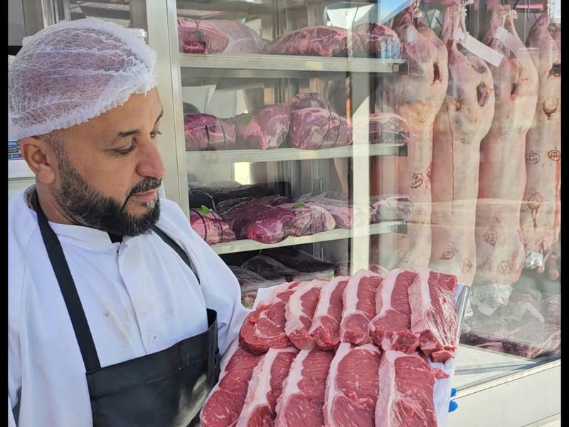 Ahmed, a butcher at Ikhlas Halal Butcher, Bradford, holding a tray of steaks